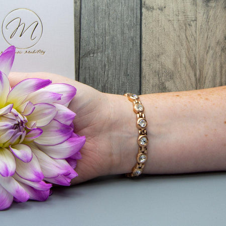 Angelica's Dawn 4in1 Magnetic Bracelet from Magnetic Mobility worn on a wrist, highlighting Swarovski crystals and rose gold design. Includes 4in1 elements: neodymium magnets, FIR elements, germanium, and negative ions for stylish pain relief.