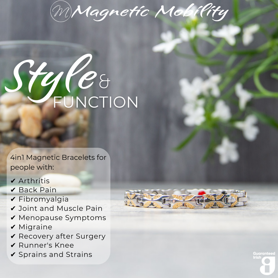 Front view of the Meadowsweet Moon 4in1 magnetic bracelet by Magnetic Mobility, promoting arthritis, back pain, fibromyalgia relief with a stylish silver and gold butterfly design. The bracelet is shown in front of delicate white flowers.