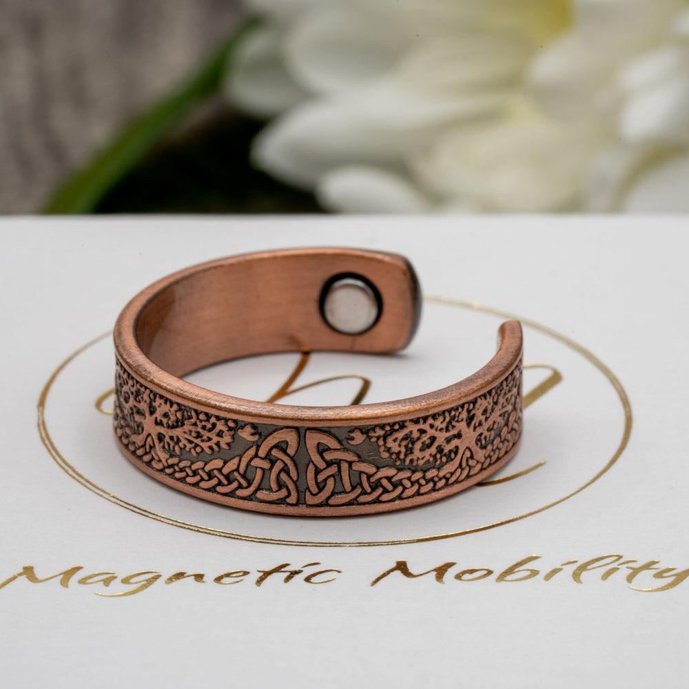 Side view of the Buckthorn copper ring by Magnetic Mobility showcasing the detailed Tree of Life design. The ring's open back design ensures a comfortable fit for arthritic fingers.