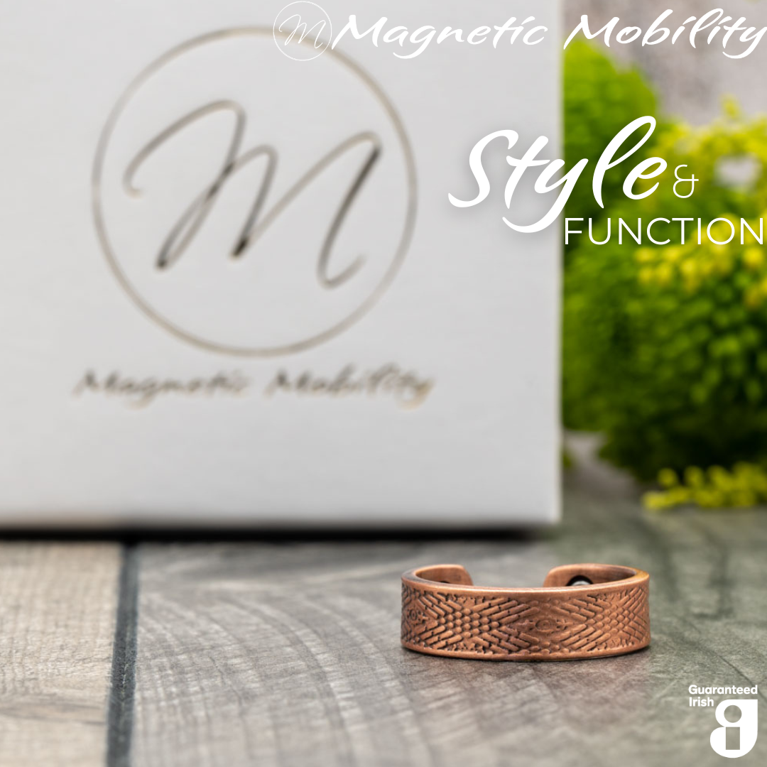 Hawthorn copper ring by Magnetic Mobility featuring an intricate geometric design. Ring is shown in front of a white branded gift box. This adjustable ring is designed to be easily worn on arthritic fingers, providing both style and functionality.