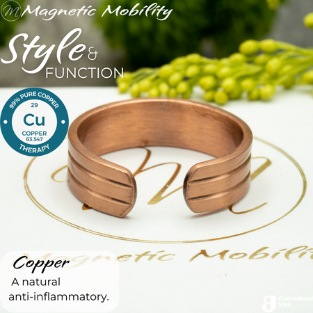 Back view of the Heath copper ring from Magnetic Mobility. Shown on a white gift box with green plants in the background. The writing says "Style and Function" and shows a Guaranteed irish logo. The back is open to allow for swelling of arthritic fingers. 