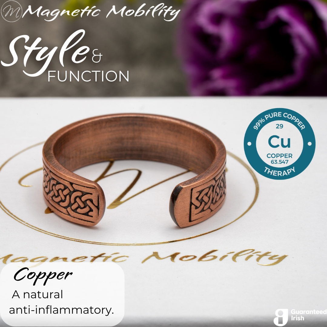 Back view of the Privet copper ring from Magnetic Mobility. Shown on a white gift box with purple plants in the background. The writing says "Style and Function" and shows a Guaranteed Irish logo. The back is open to allow for swelling of arthritic fingers.