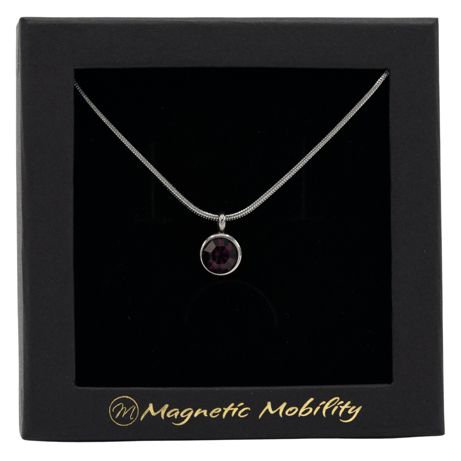 February Magnetic Mobility Birthstone Necklace with a deep purple Swarovski crystal pendant. Designed to alleviate neck pain, showcased in a black box with Magnetic Mobility logo.