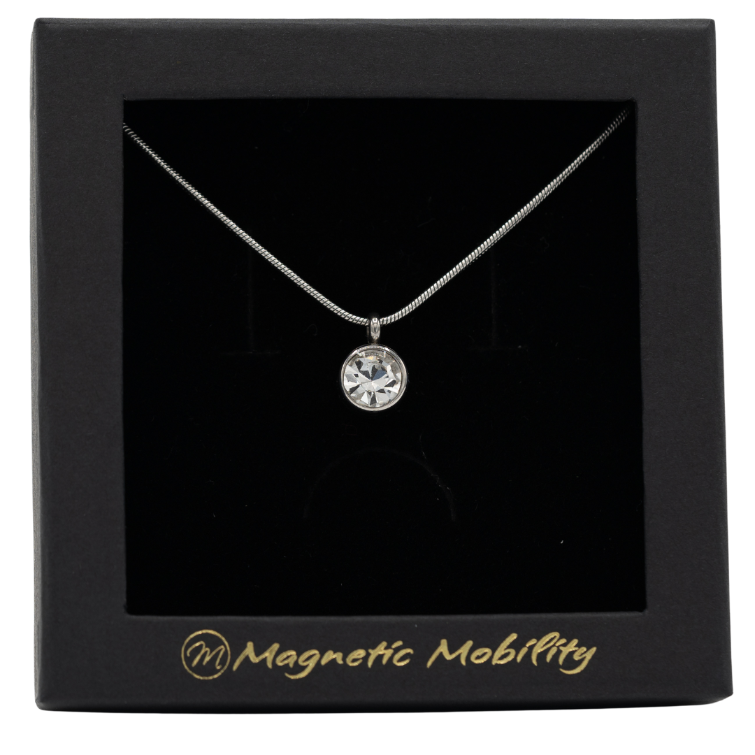 April Magnetic Mobility Birthstone Necklace showcasing a clear Swarovski crystal pendant with a magnetic back. Provides neck pain relief, elegantly boxed with Magnetic Mobility branding.