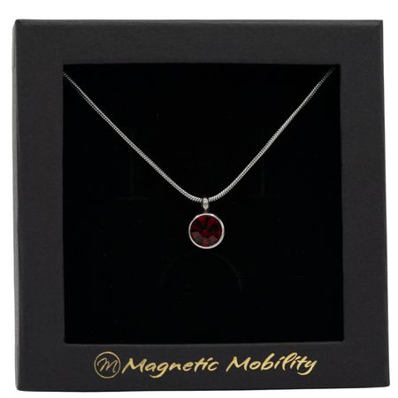 July Birthstone Necklace by Magnetic Mobility featuring a dark red Swarovski crystal pendant with a magnetic back. Perfect for alleviating neck pain, showcased in black packaging.