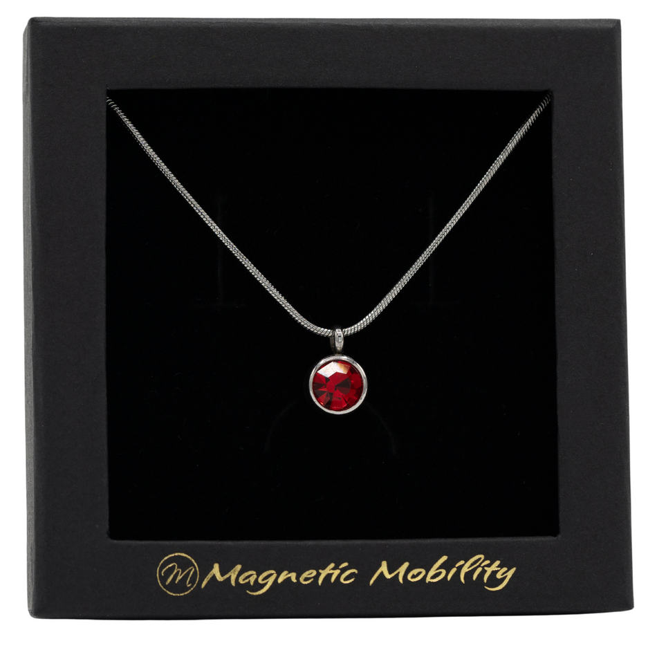 January Magnetic Mobility Birthstone Necklace featuring a red Swarovski crystal pendant with a magnetic back. Ideal for relieving neck pain, elegantly presented in black packaging with Magnetic Mobility branding.